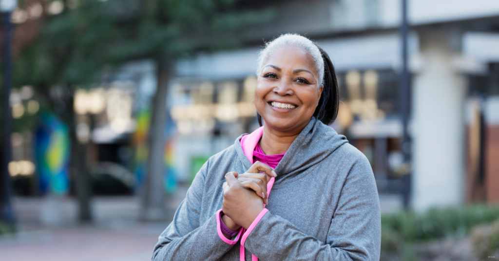 A middle aged Black woman smiles at the camera