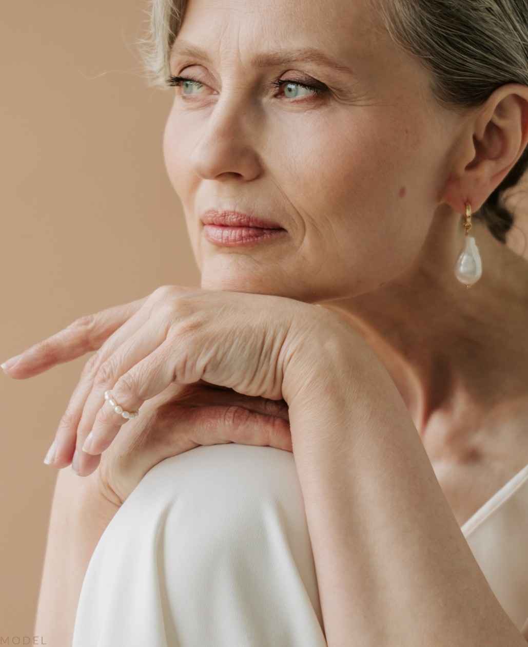 Woman in a white dress sitting on a chair (model)