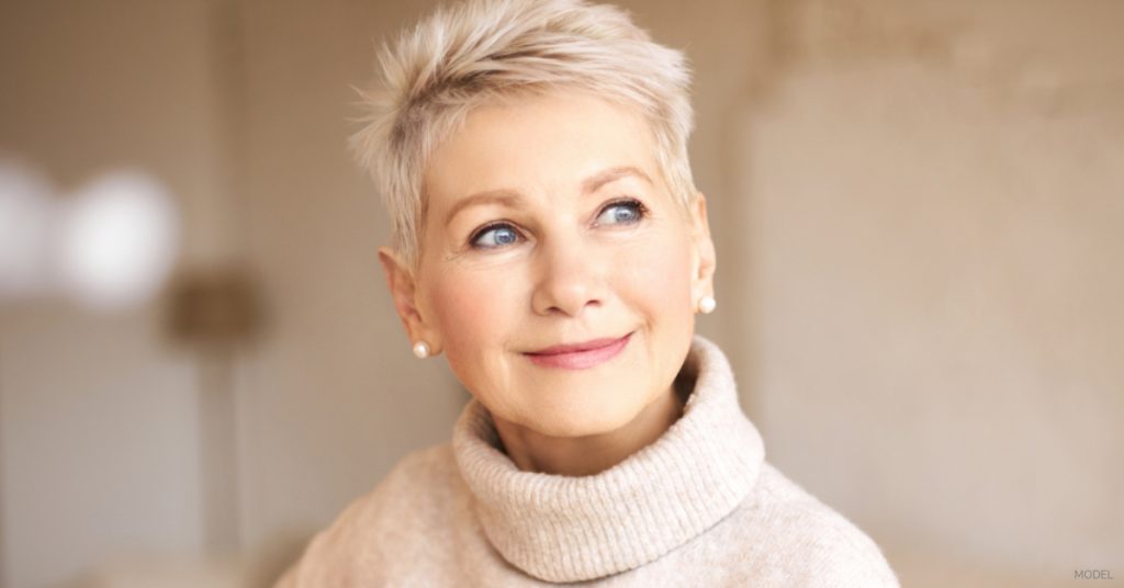 Mature woman smiling post eyelid surgery recovery (model)